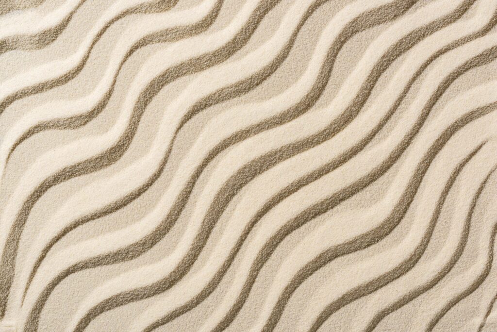 Wavy patterns in smooth sand creating an abstract texture
